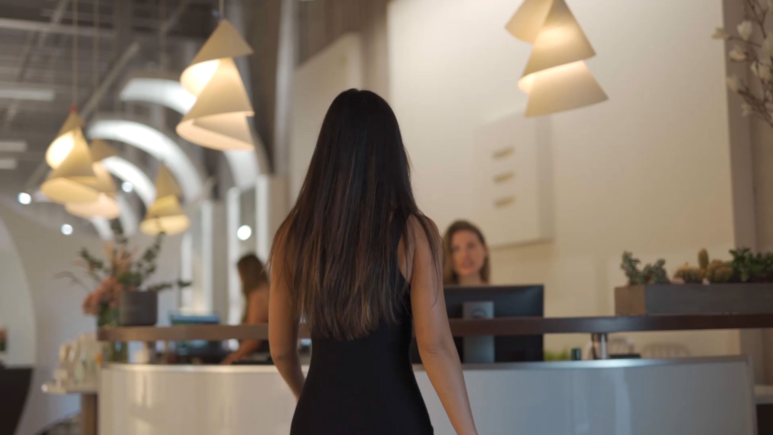 background video still of client at spa front desk